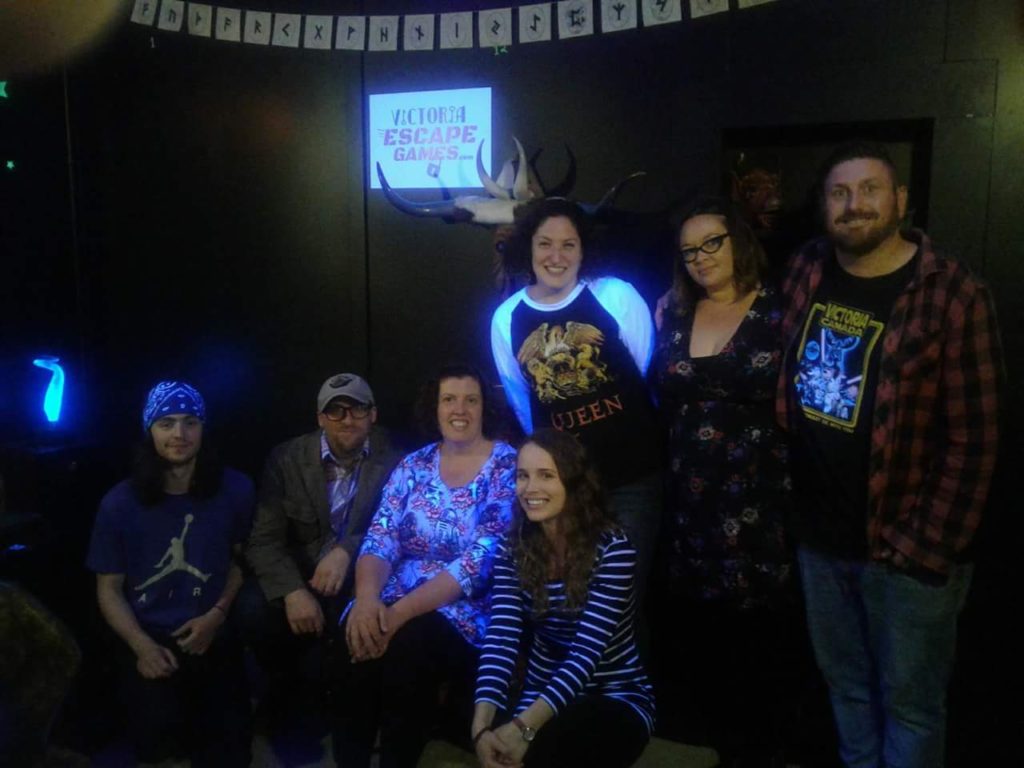 The AE team in a dark escape room, everyone smiling after successfully completing the challenge.